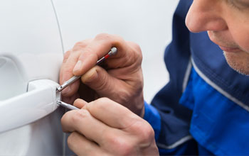 auto locksmith gaining entry to parked vehicle