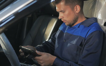 a car locksmith programming a key transponder