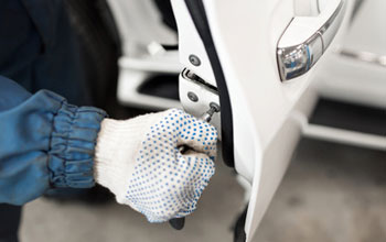 an auto locksmith engineer replacing a drivers door lock